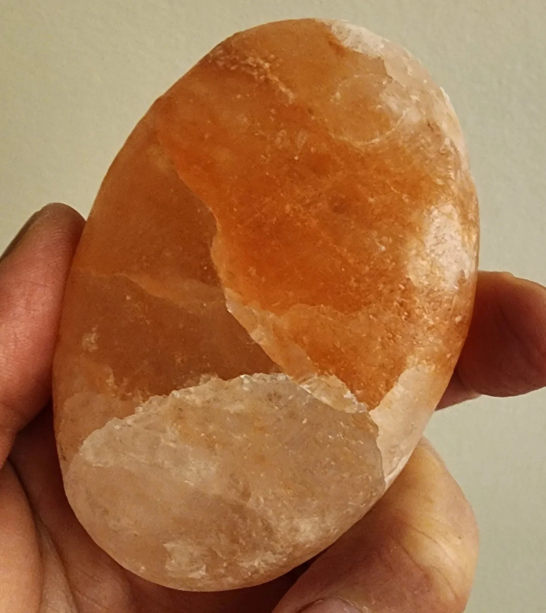 Hand holding a large exfoliating stone made of HImalayan Salt