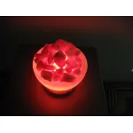 Hand-carved salt bowl lamp glowing with illuminated salt pieces